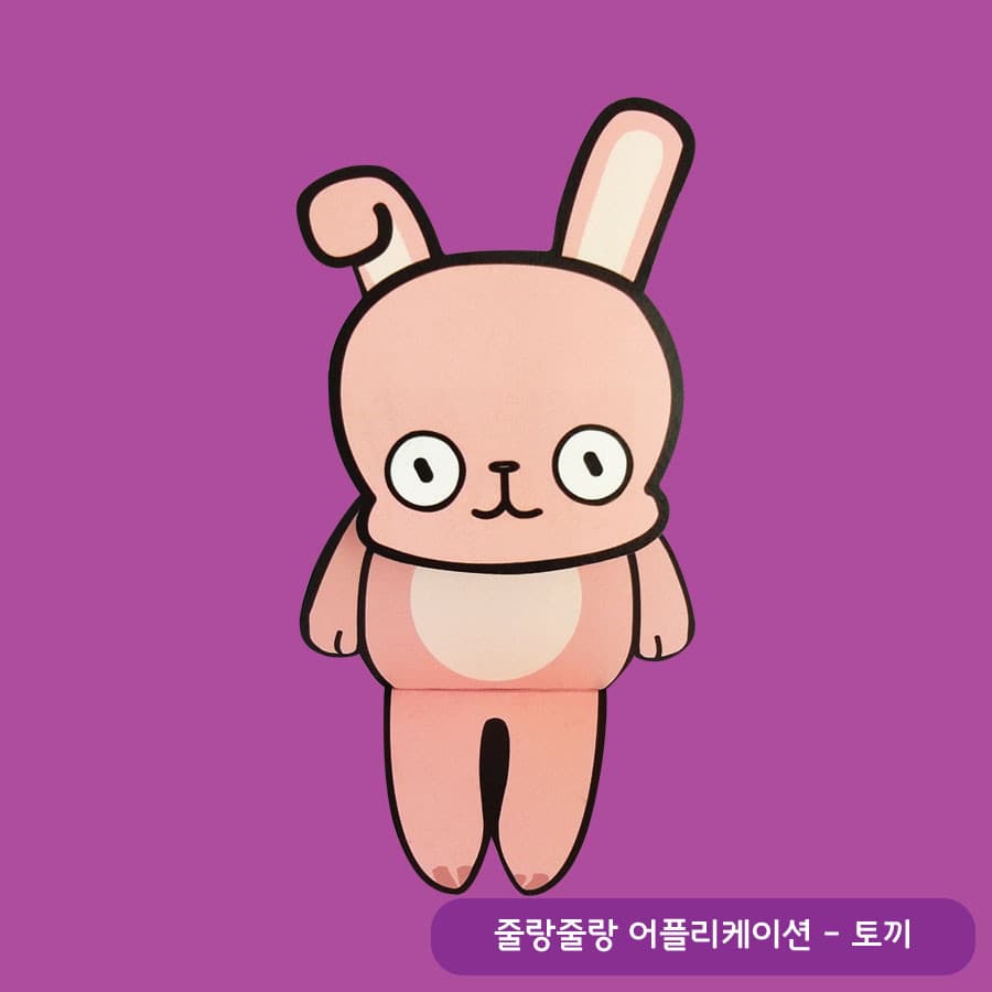 보라색 배경 위에 한쪽 귀가 접힌 분홍 토끼가 동그란 눈을 뜨고 두 팔을 내린 채 서 있는 캐릭터 종이 모형