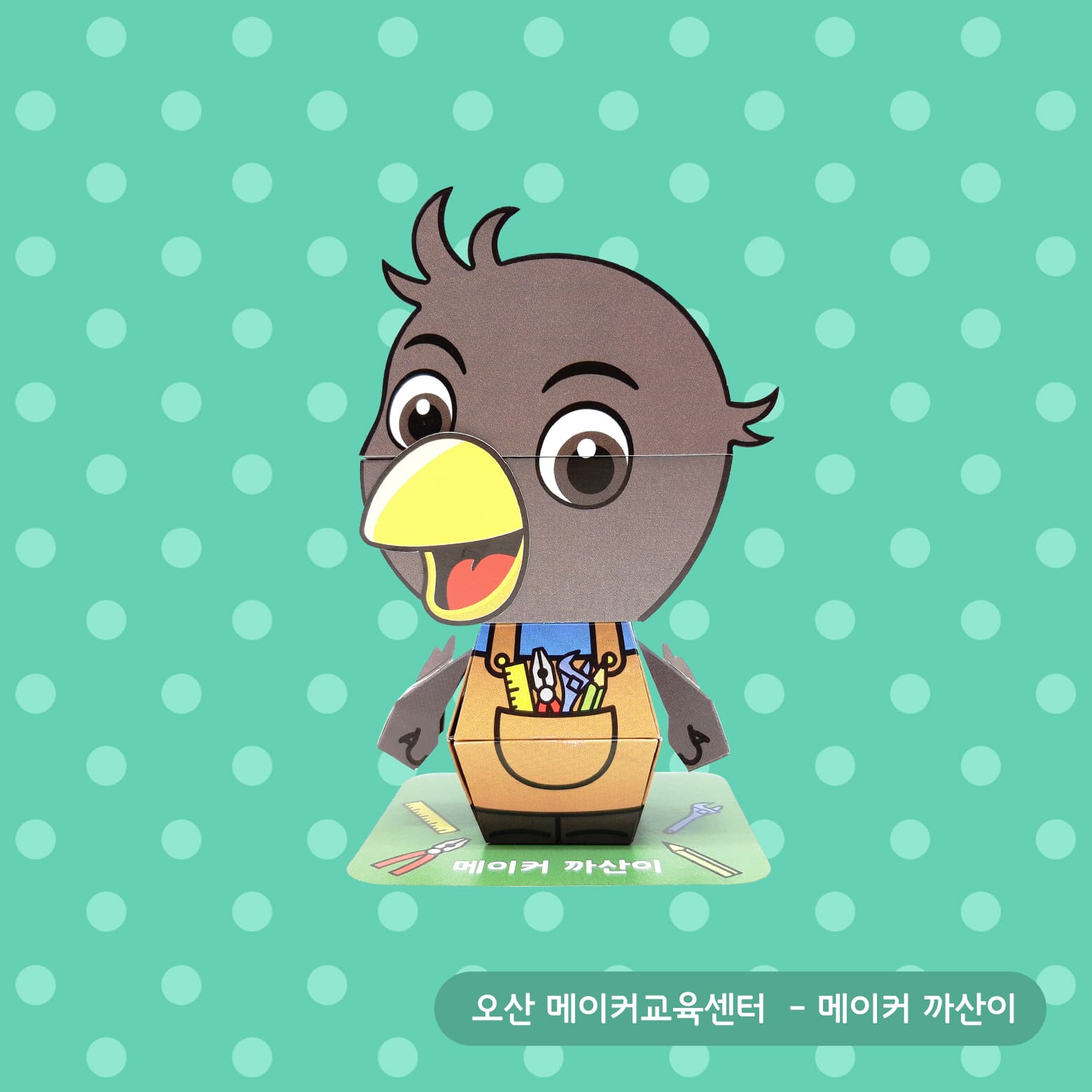 노란 부리를 벌린 회색 까치가 펜치와 자를 꽂은 공구 주머니를 멘 채 초록 물방울무늬 배경 앞에 선 메이커 까산이